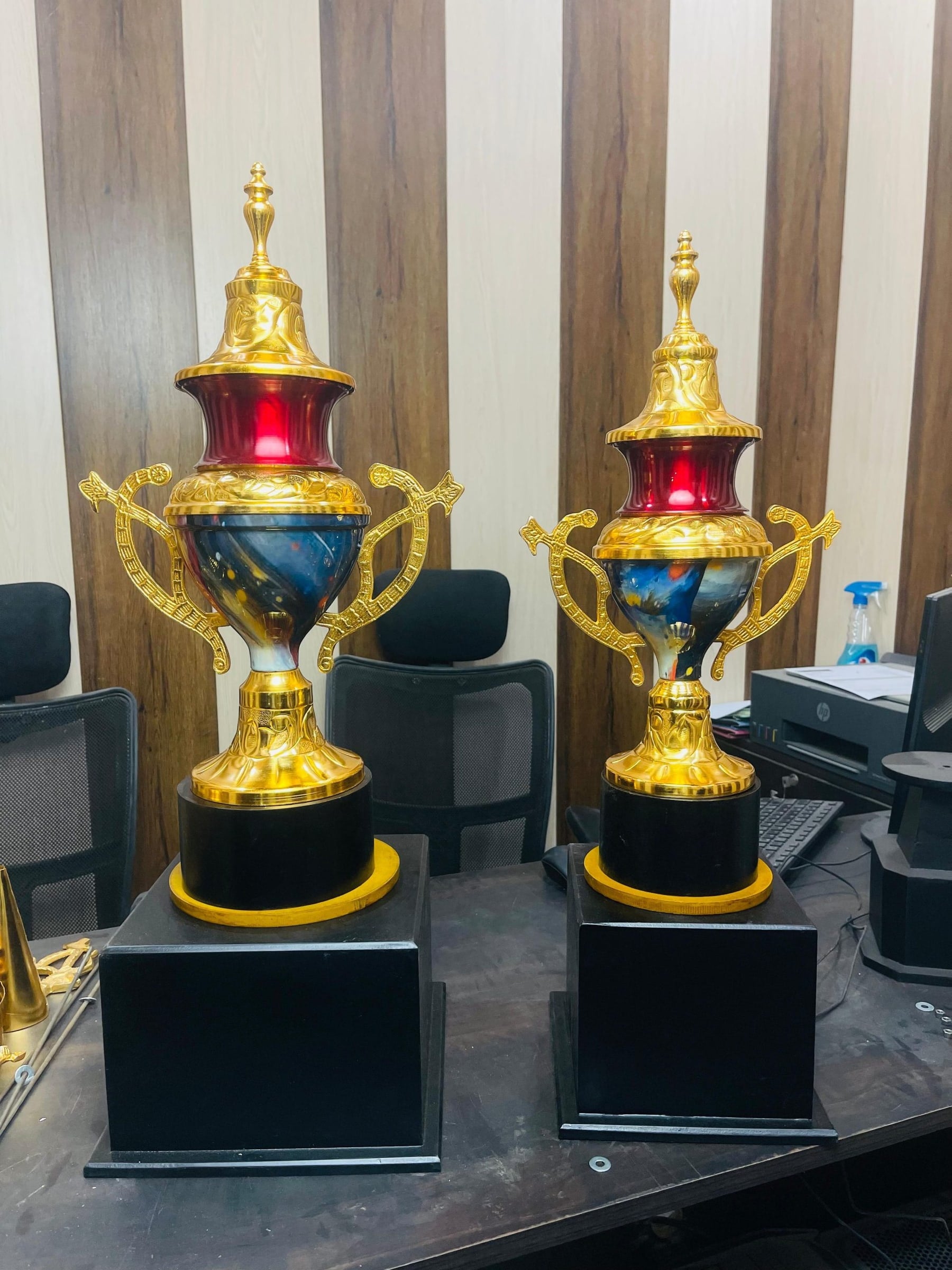 Two Monster Cups with red domes, marbled bowls, gold serpent handles and black plinths