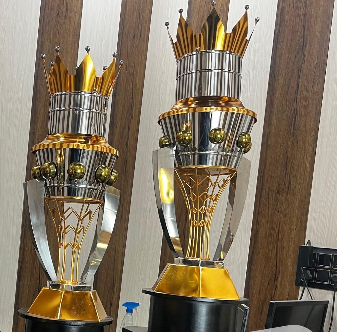 Two Eiffel Tower Cups: tiered chrome and gold towers with crown tops